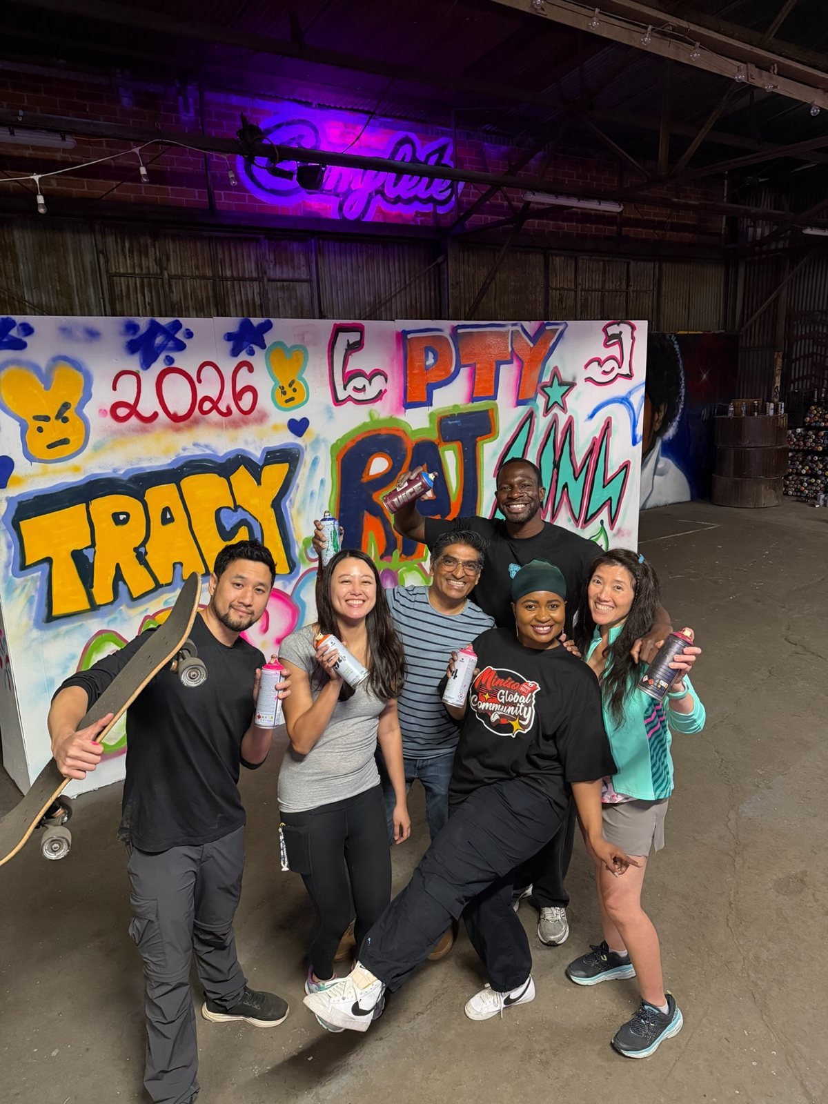 Workshop group posing with their completed graffiti wall at Complete Studio