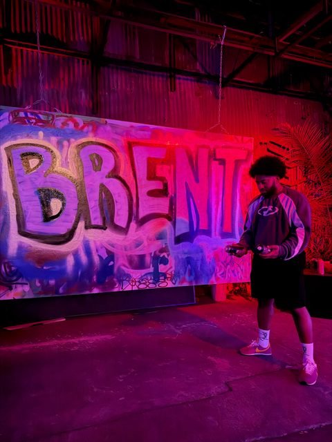 Purple BRENT graffiti under pink studio lighting