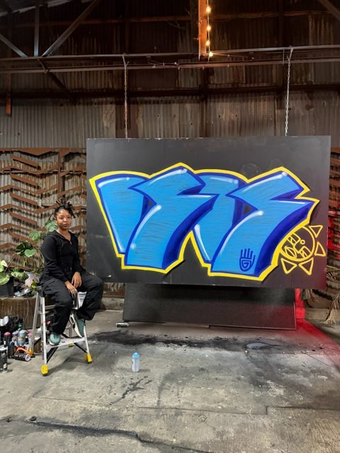 Workshop guest with a blue and yellow graffiti piece