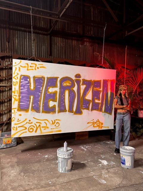 Workshop guest with a purple and yellow graffiti piece